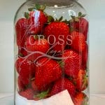 Gallon-Size Mason Jar etched with The Cross Legacy filled with fresh strawberries.