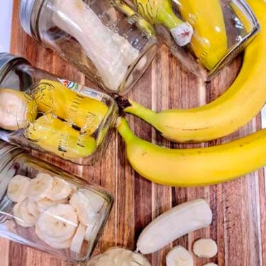 whole-bananas-cut-bananas-and-bananas-in-mason-jars-laid-out-on-a-wooden-cutting-board
