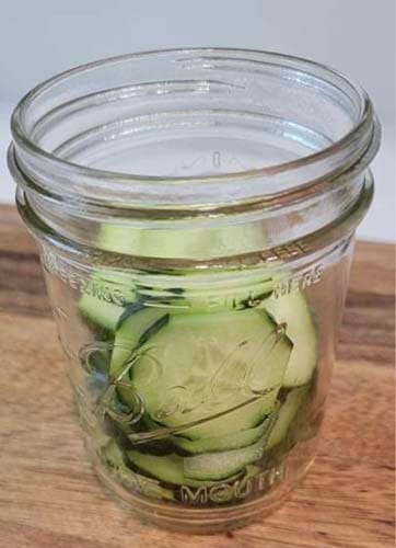 jar filled with sliced cucumbers ready to add to a salad
