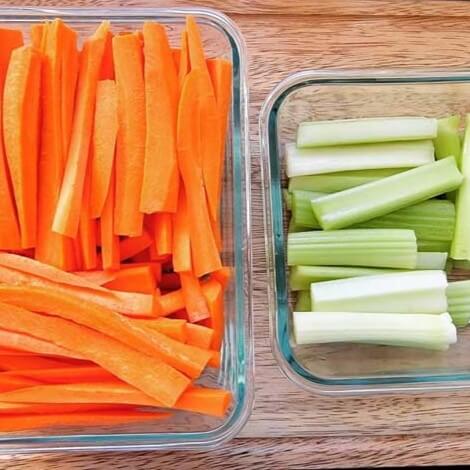 glass pyrex containers with cut carrots and celery ready to add to a salad