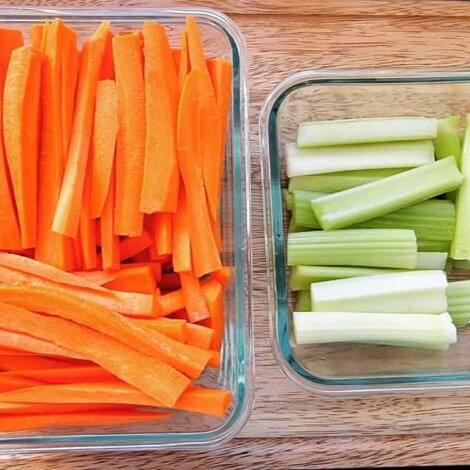 glass pyrex containers with cut carrots and celery ready to add to a salad
