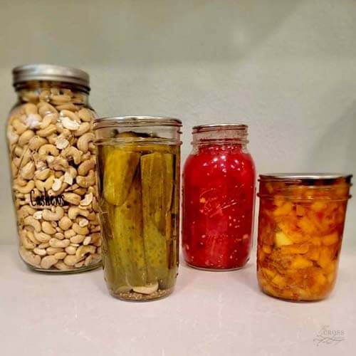 装有罐装西红柿、酸黄瓜和腰果的玻璃罐子