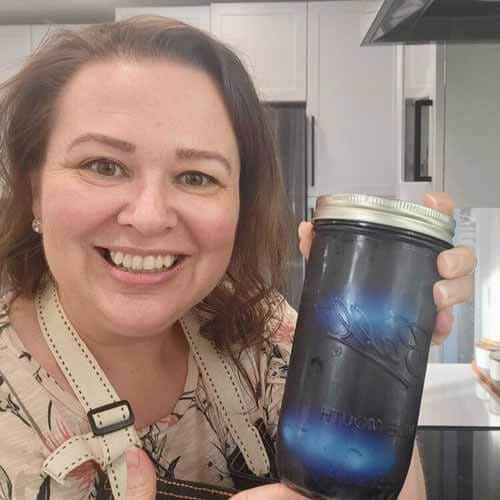 Amy holding up jar of natural Easter egg dye made from red cabbage