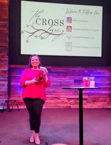 Amy holding jar of strawberry timers at MOPS event