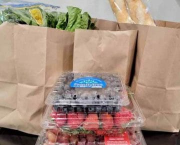 柜台上纸袋装的食品杂货，水果，蔬菜和面包