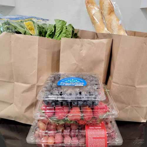 柜台上纸袋装的食品杂货，水果，蔬菜和面包