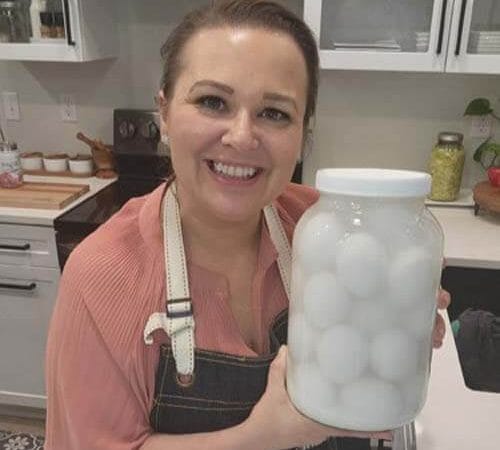 amy-cross-holding-a-jar-of-water-glass-eggs-in-her-kitchen