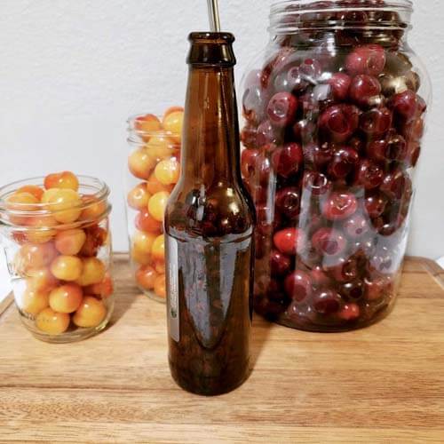 cherries-in-mason-jars-and-an-empty-root-beer-bottle-which-can-be-used-as-a-cherry-pittergydF4y2Ba