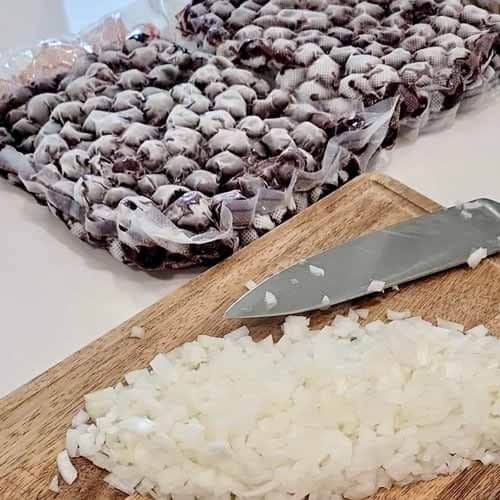 block-of-frozen-cherries-and diced-fresh-onions-on-a-wooden-cutting-block-with-a-chef的刀gydF4y2Ba