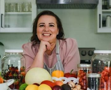 amy-cross-at-her-kitchen-counter-with-a-spread-of-fresh-produce-for-her-happy-1st-anniversary-photo-shoot-of-her-business
