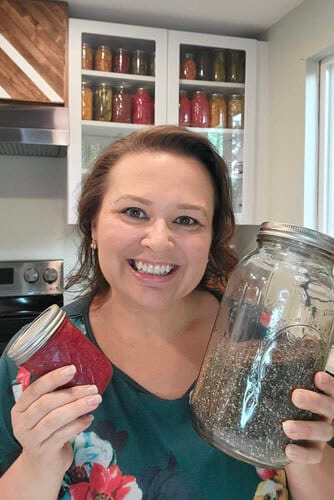 amy-cross-holding-strawberry-jam-and-chia-seeds-in-her-kitchen