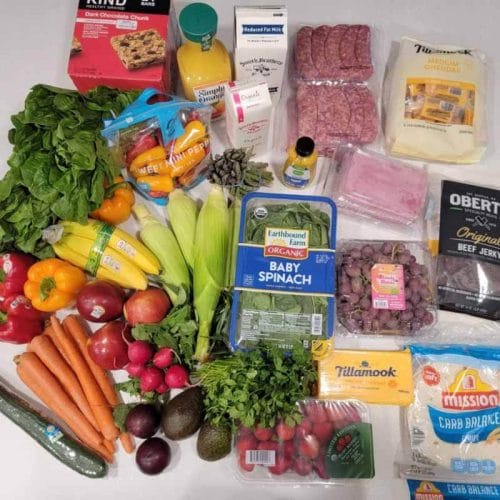 价值135美元的食品杂货的照片——新鲜农产品、肉类、奶酪、包装纸、巧克力棒等。