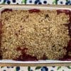 fully cooked Peach Blueberry Crisp in a white baking dish cooling on a wooden cutting board