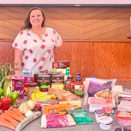 Amy on the stage of her Step-by-Step event with 5 worth of groceries