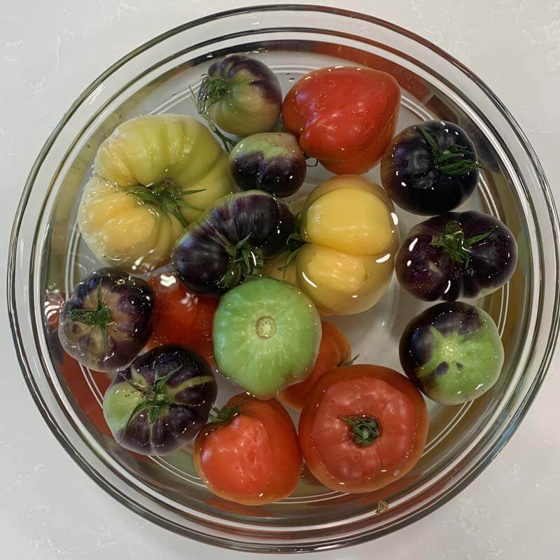 heirloom tomatoes soaking in a vinegar bath
