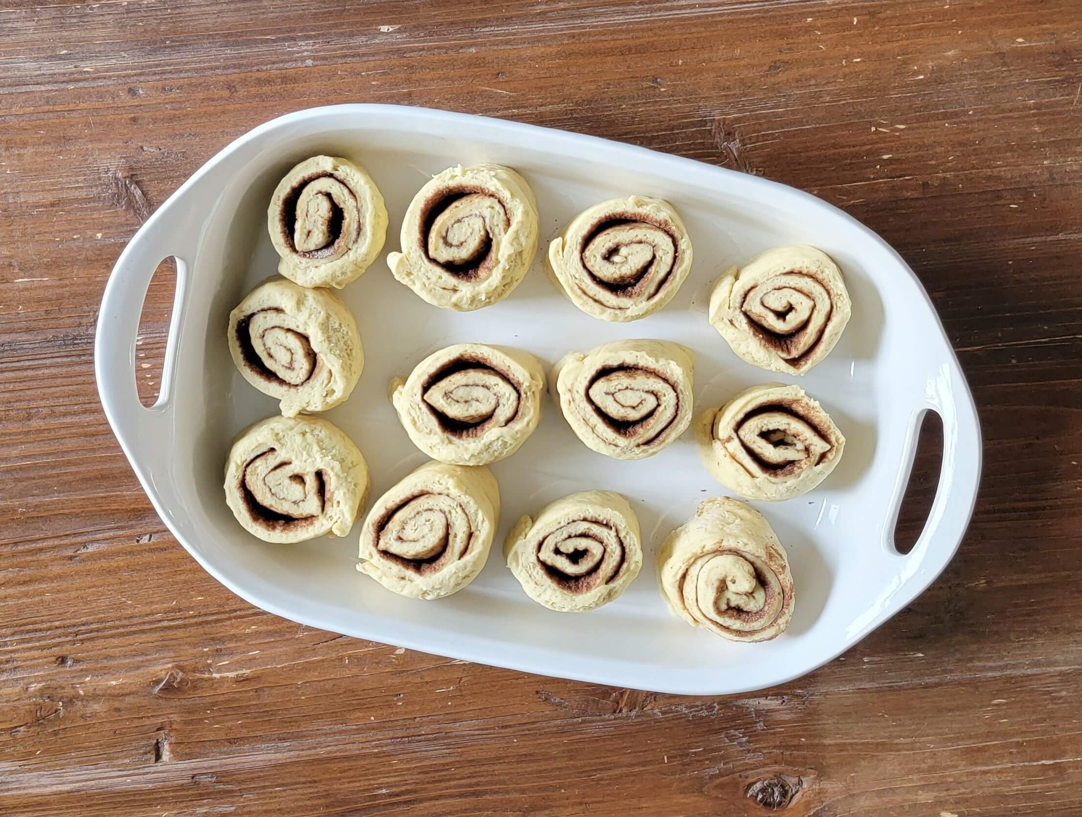 Cinnamon Rolls cut and placed in a white baking dish.