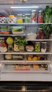 艾米12月份的冰箱照片，里面装满了玻璃容器里的新鲜农产品。