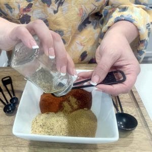 艾米测量所有需要做她自制玉米卷调味料的香料:大蒜粉，孜然粉，辣椒粉，烟熏辣椒粉，牛至，盐和胡椒。gydF4y2Ba