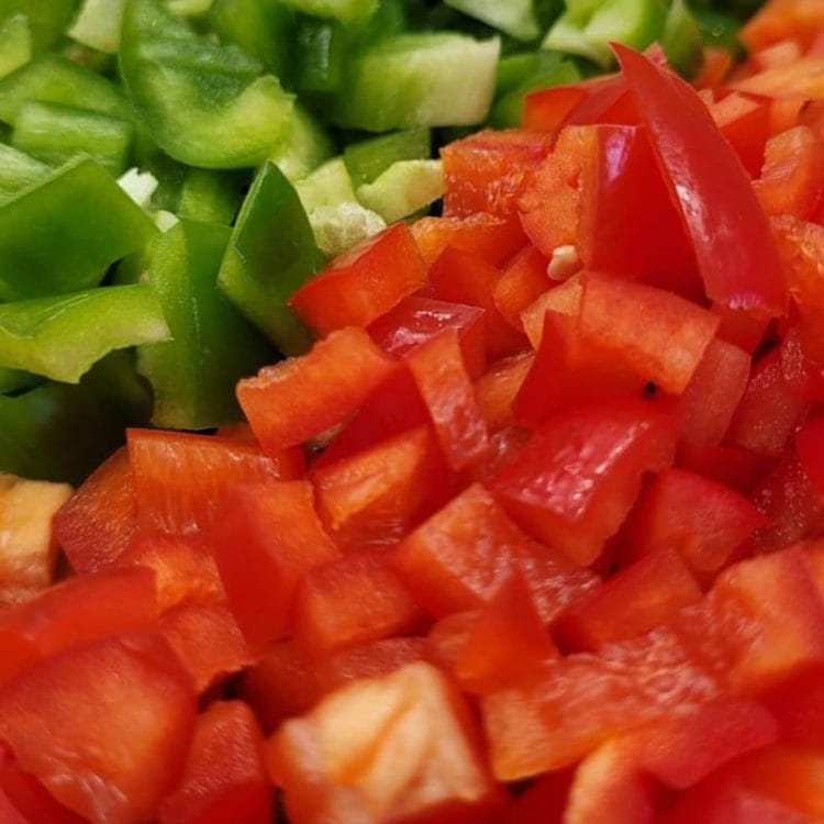 close up of chopped red and green peppers.