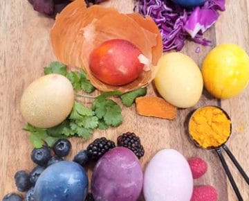 Naturally dyed Easter Egg on a cutting board with their corresponding dyed ingredients.