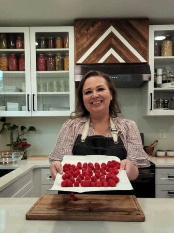 Amy holding a Plate of Fresh Raspberries in her kitchen