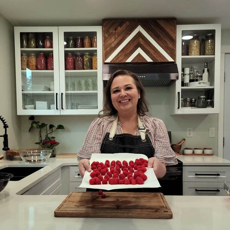Amy holding a Plate of Fresh Raspberries in her kitchen