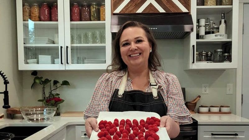 Amy holding a Plate of Fresh Raspberries in her kitchen