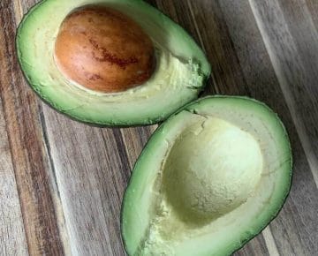 A beautiful avocado on a wooden cutting board - showing you how to pick the perfect avocado.