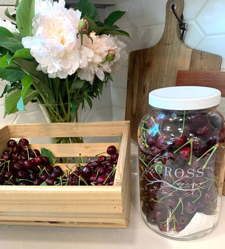 Cherries in a wooden crate and mason jar.