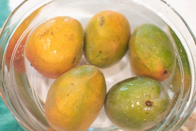 Washing Mangos in a Glass Bowl of Vinegar Water.
