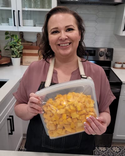 Amy holding a Stasher bag of frozen mango pieces.