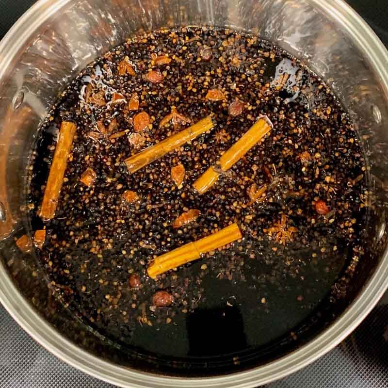 Pot of homemade elderberry syrup cooking on the stove
