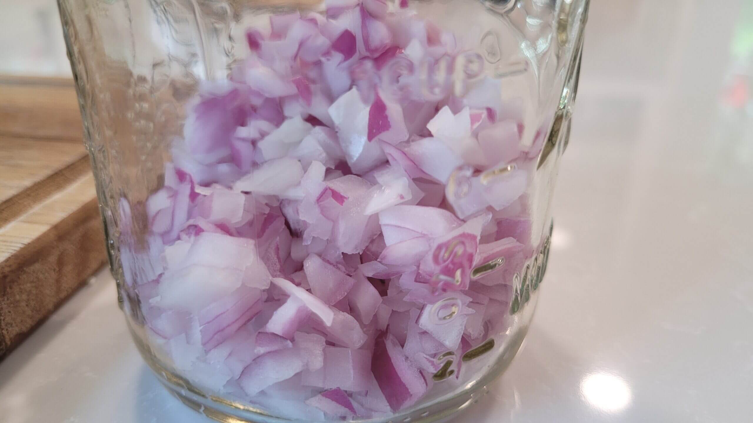 chopped onions in a glass jar